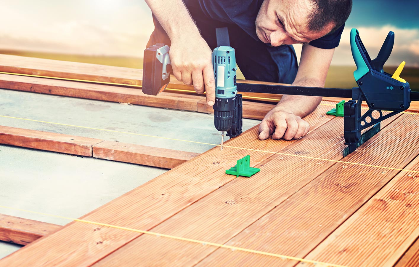 Mann montiert Terrassendielen aus Holz